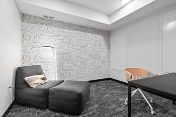 a small room with a couch and a chair and a desk